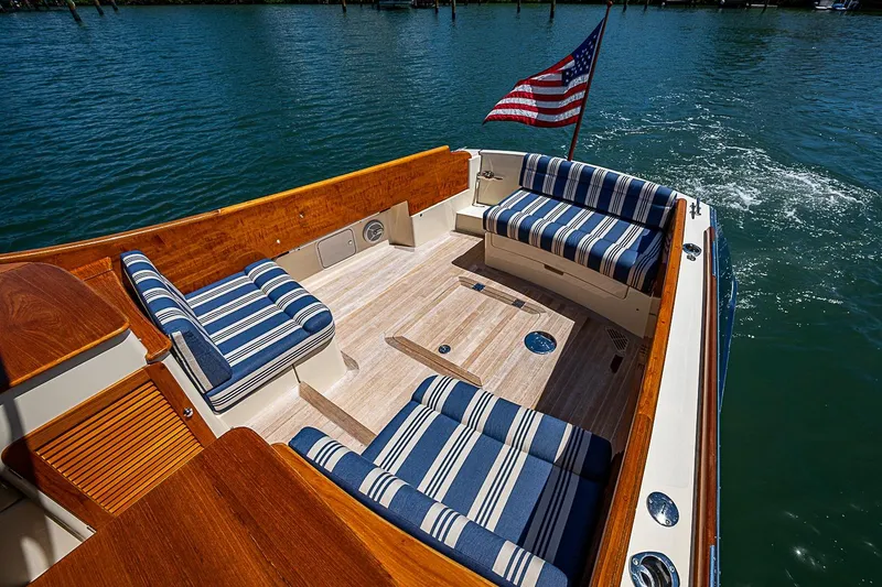 Slide: The Image of 2016 Hinckley Picnic Boat 37 MKIII with striped seating and American flag on water. - 6