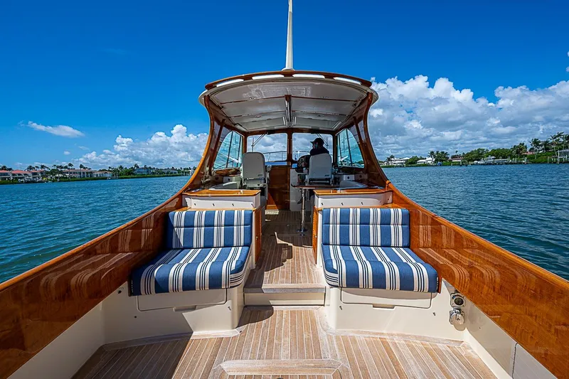 Slide: The Image of 2016 Hinckley Picnic Boat 37 MKIII on water, featuring striped seating and wooden deck. - 7