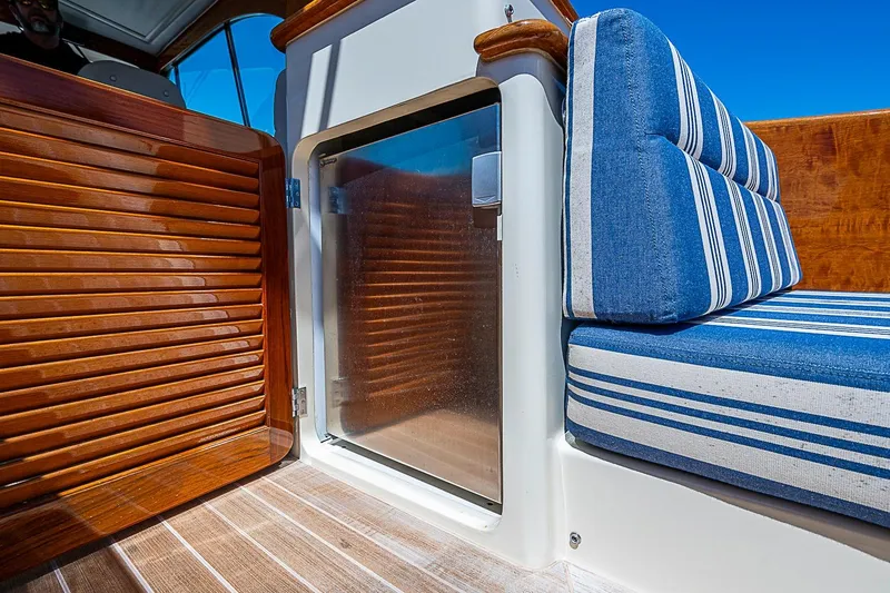 Slide: The Image of 2016 Hinckley Picnic Boat 37 MKIII interior with striped seating and wooden accents. - 9