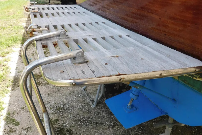 Slide: The Image of 1995 Lyman 27 Cruisette swim platform with metal railings and wooden slats. - 40