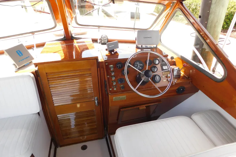 Slide: The Image of 1995 Lyman 27 Cruisette boat cockpit with wooden dashboard and steering wheel. - 13