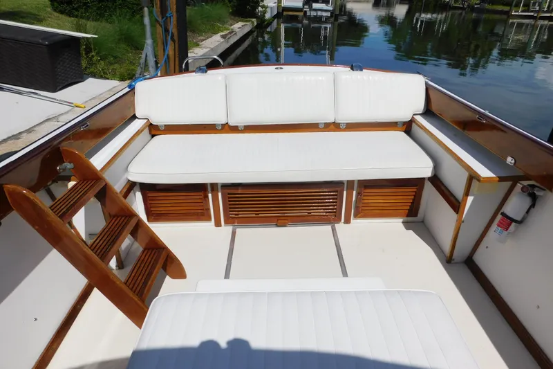 Slide: The Image of Interior of a 1995 Lyman 27 Cruisette boat with white seating and wooden accents. - 20