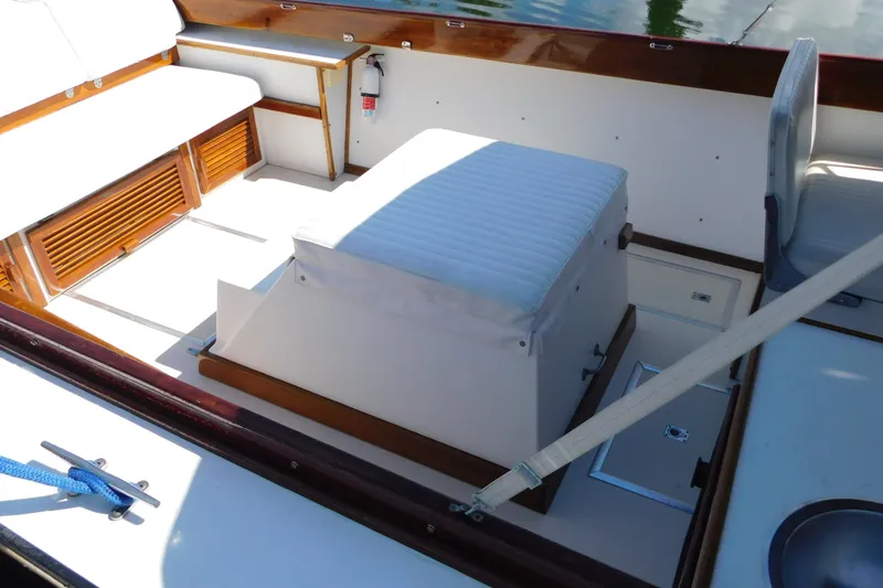 Slide: The Image of Interior of a 1995 Lyman 27 Cruisette boat with seating and storage. - 22