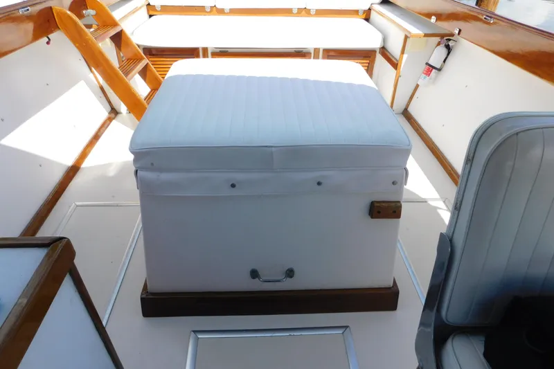 Slide: The Image of Interior of a 1995 Lyman 27 Cruisette boat with white seating and wooden accents. - 23