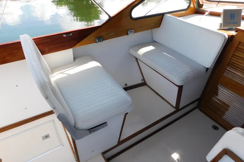Slide: The Image of Interior of a 1995 Lyman 27 Cruisette boat with white cushioned seating. - 26