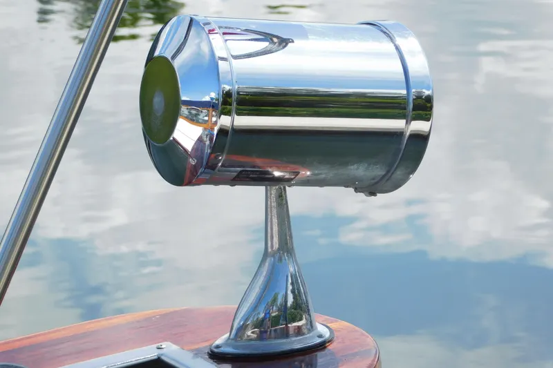 Slide: The Image of Chrome spotlight on a 1995 Lyman 27 Cruisette boat, reflecting water surface. - 32