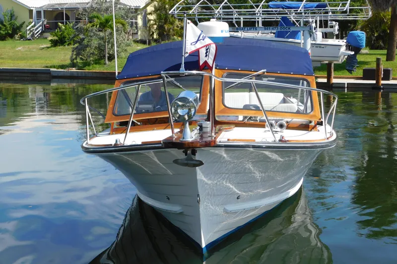 Slide: The Image of Front view of a 1995 Lyman 27 Cruisette boat docked on calm water. - 5