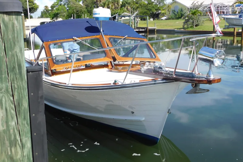 Slide: The Image of 1995 Lyman 27 Cruisette boat docked with blue canopy and wooden accents. - 6