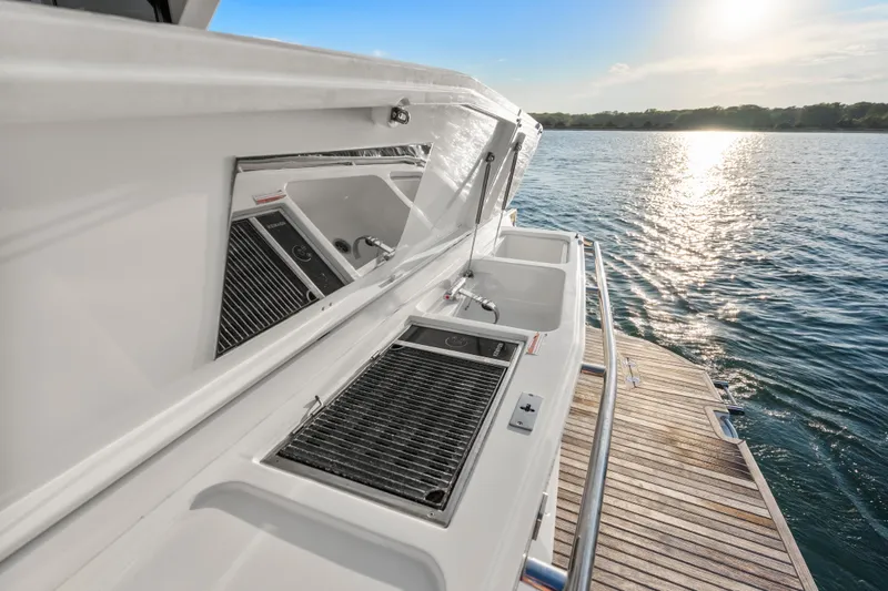 Slide: The Image of 2023 Galeon 400 Fly yacht with outdoor kitchen, overlooking serene water at sunset. - 11