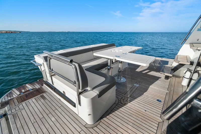 Slide: The Image of 2023 Galeon 400 Fly yacht deck with seating and table, overlooking the ocean. - 14