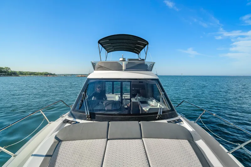 Slide: The Image of 2023 Galeon 400 Fly yacht cruising on open water under clear blue skies. - 16