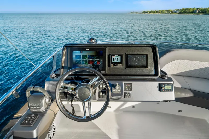 Slide: The Image of 2023 Galeon 400 Fly yacht helm with modern navigation displays on open water. - 44