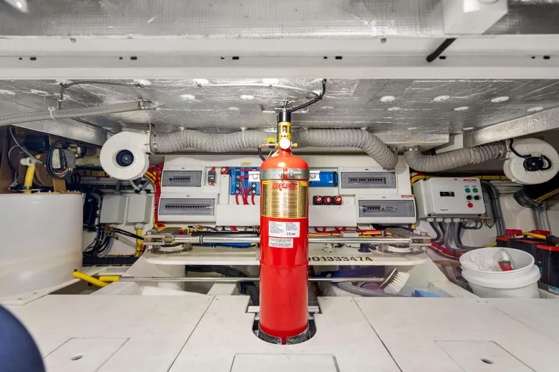 Slide: The Image of Engine room of 2023 Galeon 400 Fly yacht with fire extinguisher and control panels. - 48