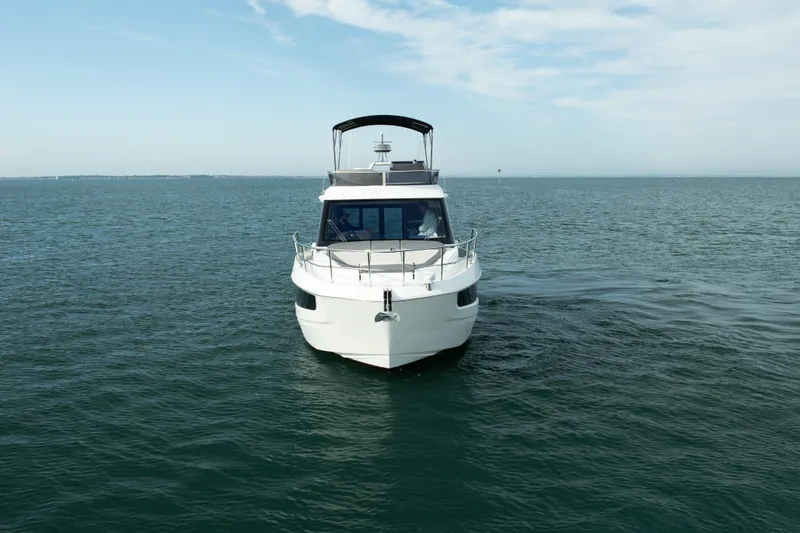 Slide: The Image of 2023 Galeon 400 Fly yacht cruising on open water under a clear sky. - 8