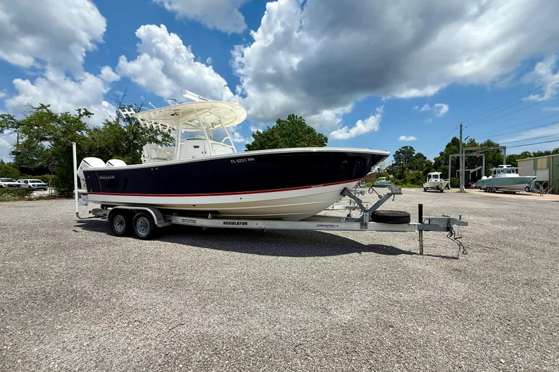The Image of 2017 Regulator 28 boat on trailer under cloudy sky in parking lot. - 0