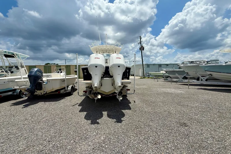 Slide: The Image of 2017 Regulator 28 boat with twin engines in a boatyard under a cloudy sky. - 2