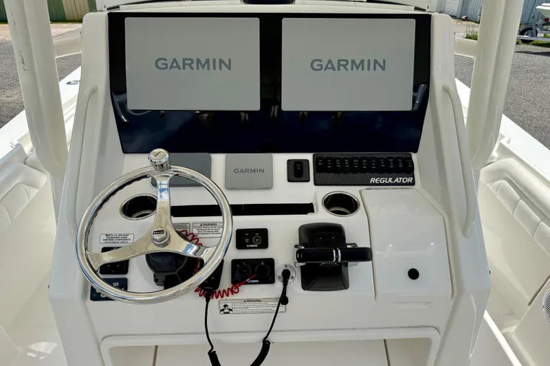 Slide: The Image of 2017 Regulator 28 boat dashboard with dual Garmin displays and steering wheel. - 4