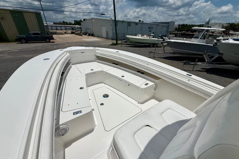 Slide: The Image of 2017 Regulator 28 boat interior with spacious seating and storage, parked outdoors. - 6