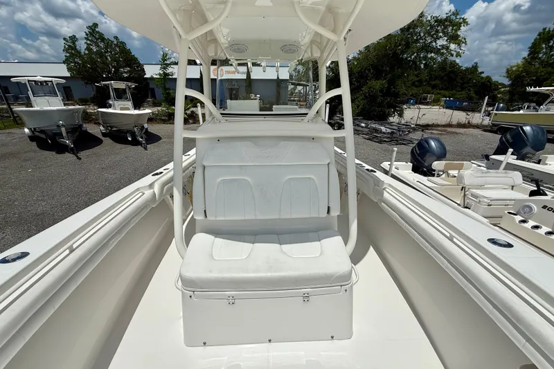 Slide: The Image of 2017 Regulator 28 boat interior with seating, parked outdoors under a cloudy sky. - 7