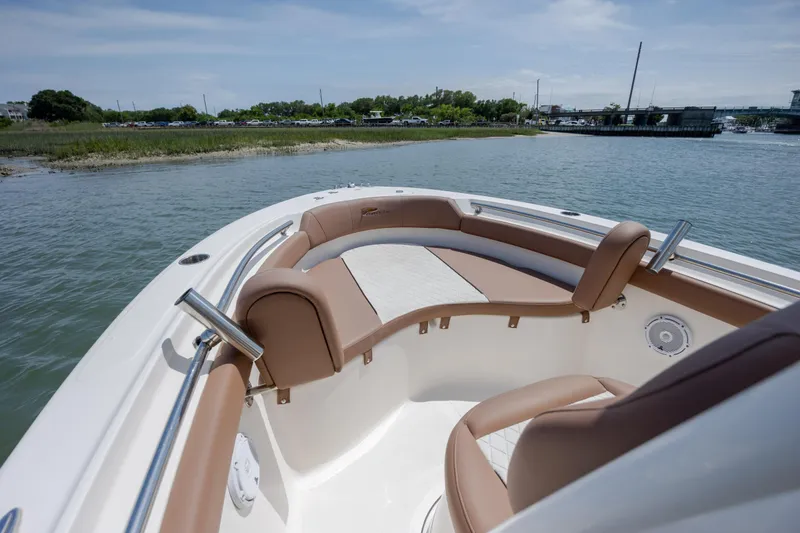 Slide: The Image of 2022 Pioneer 202 Islander boat with tan seating, docked near a scenic shoreline. - 11