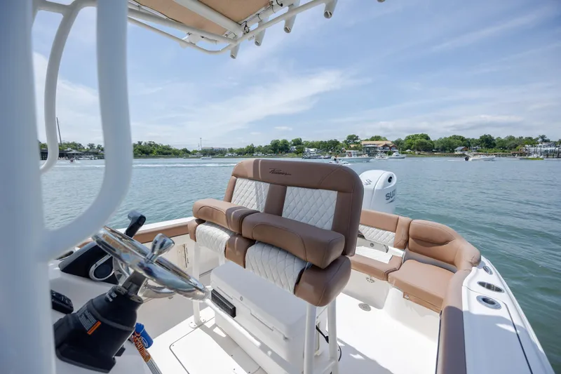 Slide: The Image of 2022 Pioneer 202 Islander boat interior with plush seating on a sunny day. - 15