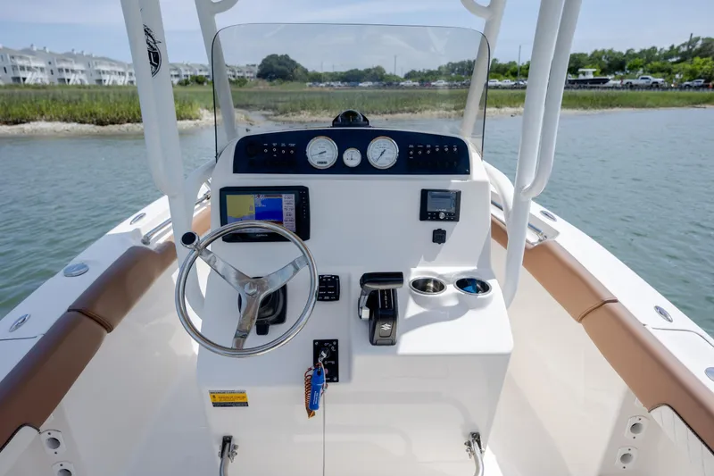Slide: The Image of 2022 Pioneer 202 Islander boat dashboard with steering wheel and navigation instruments. - 17