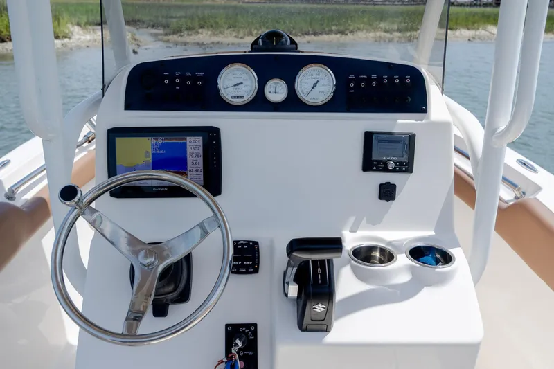 Slide: The Image of 2022 Pioneer 202 Islander boat dashboard with steering wheel, gauges, and navigation system. - 18