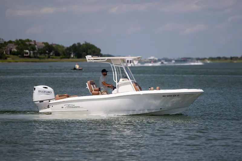 Slide: The Image of 2022 Pioneer 202 Islander boat cruising on a calm lake with Suzuki outboard motor. - 2