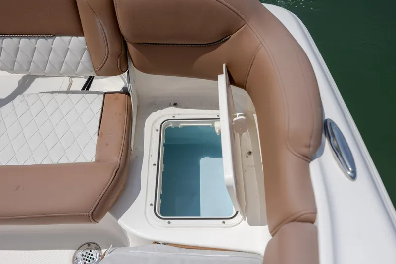 Slide: The Image of 2022 Pioneer 202 Islander boat with open storage compartment and cushioned seating. - 22