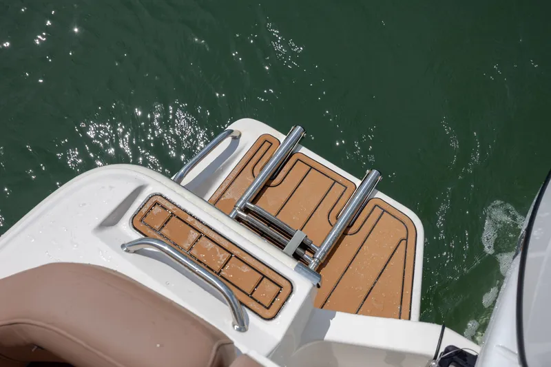 Slide: The Image of 2022 Pioneer 202 Islander boat swim platform with ladder on water. - 23