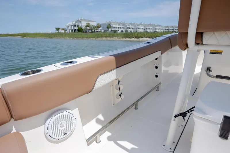 Slide: The Image of 2022 Pioneer 202 Islander boat interior with tan seating, near waterfront buildings. - 26