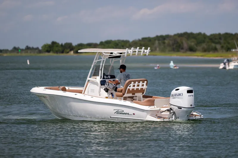 Slide: The Image of 2022 Pioneer 202 Islander boat cruising on a calm lake with Suzuki outboard motor. - 6