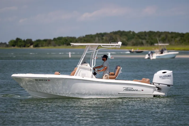 Slide: The Image of 2022 Pioneer 202 Islander boat cruising on a calm lake with a Suzuki outboard motor. - 7