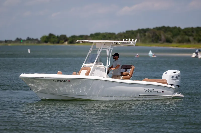 Slide: The Image of 2022 Pioneer 202 Islander boat cruising on a calm lake with a Suzuki engine. - 8