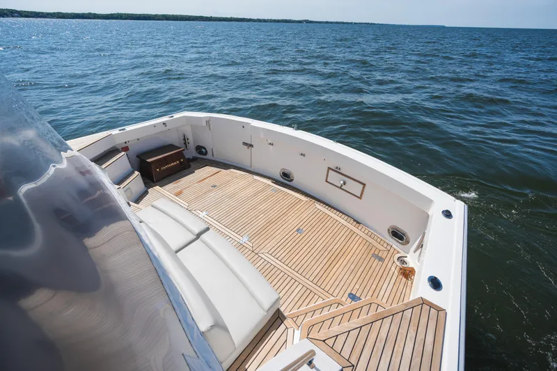 Slide: The Image of 1999 Grand Banks 49 Eastbay HX yacht deck with teak flooring on open water. - 11