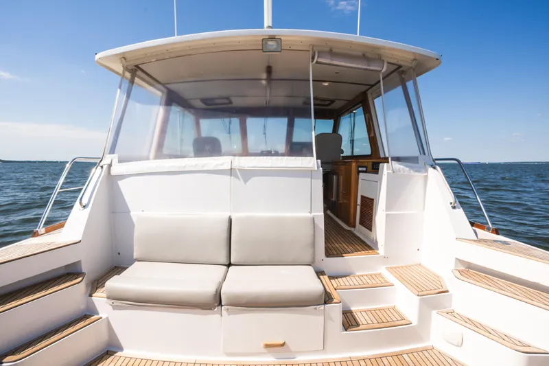 Slide: The Image of 1999 Grand Banks 49 Eastbay HX yacht with spacious deck seating on open water. - 13