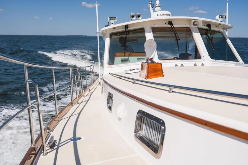 Slide: The Image of 1999 Grand Banks 49 Eastbay HX cruising on open water under clear skies. - 19