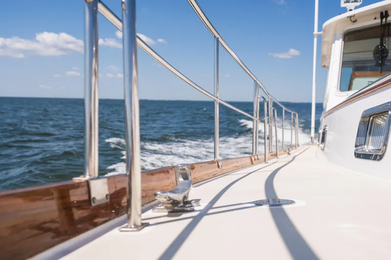 Slide: The Image of 1999 Grand Banks 49 Eastbay HX cruising on open water under clear blue skies. - 20