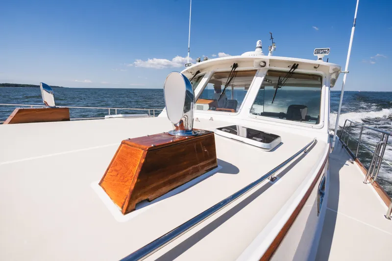 Slide: The Image of 1999 Grand Banks 49 Eastbay HX cruising on open water under clear blue skies. - 21