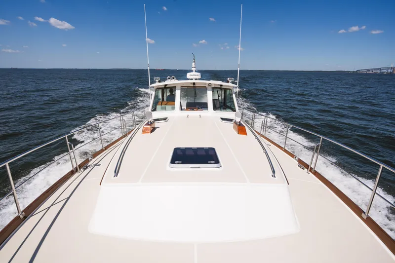 Slide: The Image of 1999 Grand Banks 49 Eastbay HX cruising on open water under clear blue skies. - 24