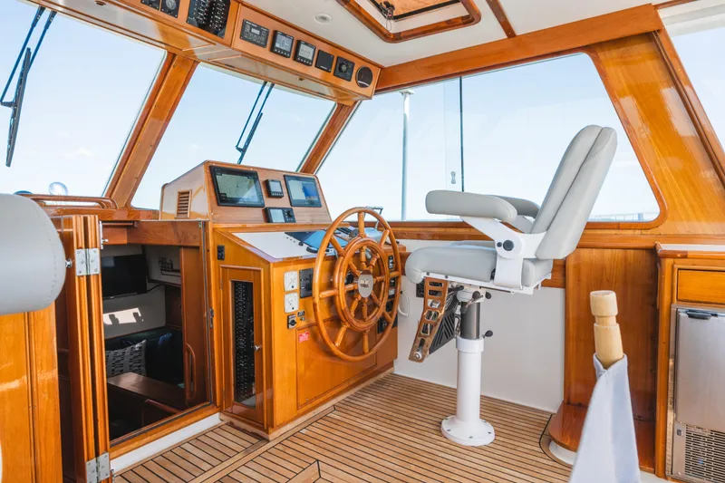 Slide: The Image of Helm of 1999 Grand Banks 49 Eastbay HX with wooden accents and modern navigation equipment. - 32