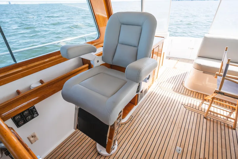 Slide: The Image of Captain's chair on 1999 Grand Banks 49 Eastbay HX yacht with teak flooring and ocean view. - 40