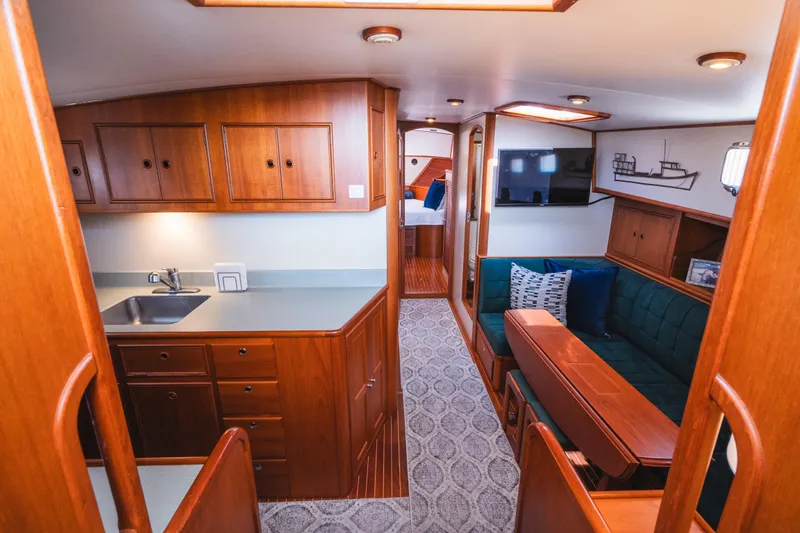 Slide: The Image of Interior of 1999 Grand Banks 49 Eastbay HX yacht with wood cabinetry and cozy seating area. - 42