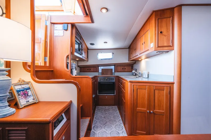 Slide: The Image of Interior of 1999 Grand Banks 49 Eastbay HX yacht with wooden cabinetry and modern kitchen amenities. - 45