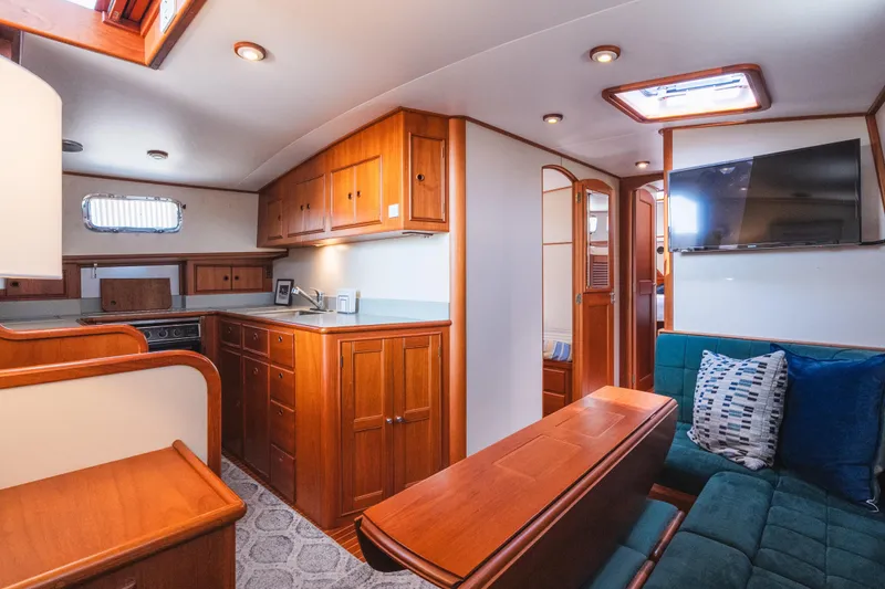 Slide: The Image of Interior of 1999 Grand Banks 49 Eastbay HX yacht with wood cabinetry and cozy seating area. - 46
