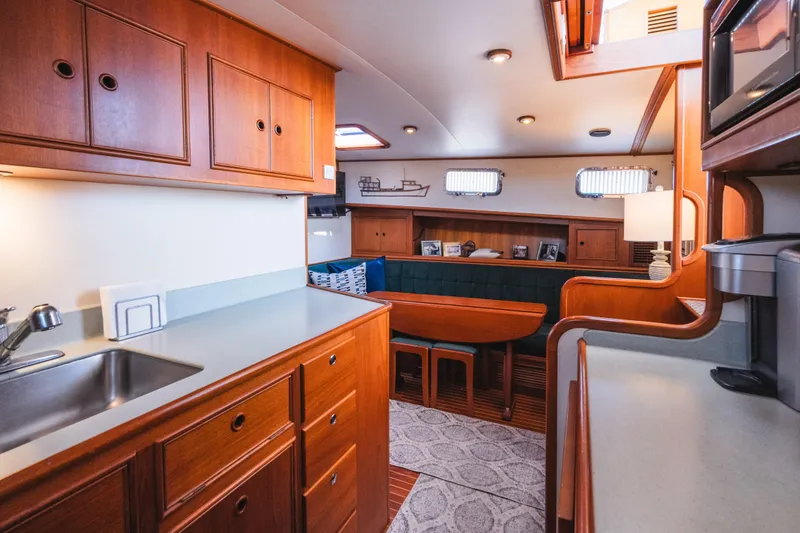 Slide: The Image of Interior of 1999 Grand Banks 49 Eastbay HX yacht with wooden cabinetry and seating area. - 48