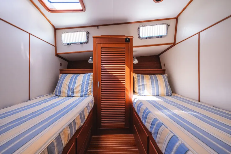 Slide: The Image of Cabin interior of 1999 Grand Banks 49 Eastbay HX with twin beds and striped bedding. - 55
