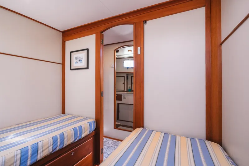 Slide: The Image of Cabin interior of 1999 Grand Banks 49 Eastbay HX with twin beds and wooden accents. - 56
