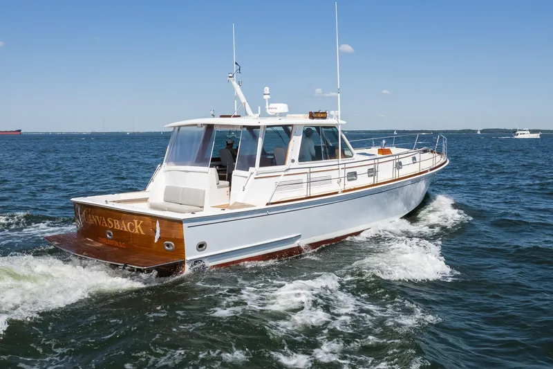 Slide: The Image of 1999 Grand Banks 49 Eastbay HX cruising on open water under clear blue skies. - 6