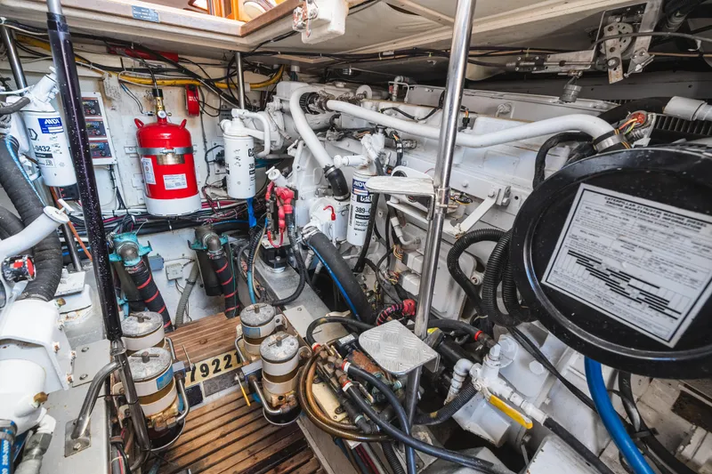 Slide: The Image of Engine room of 1999 Grand Banks 49 Eastbay HX with mechanical components and fire extinguisher. - 61